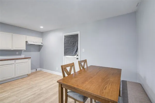 a kitchen with a table chairs sink and cabinets