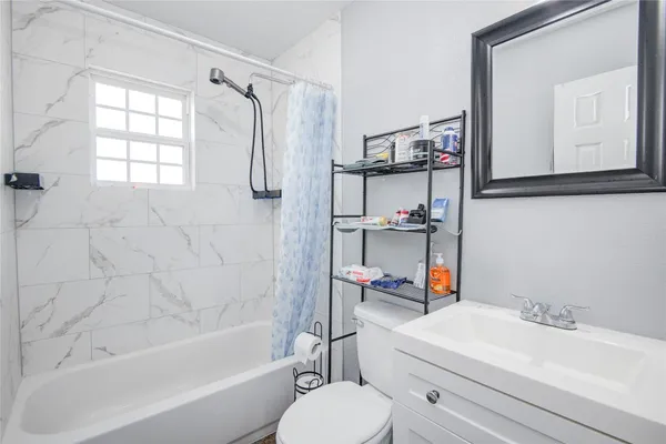 a bathroom with a sink vanity mirror and tub