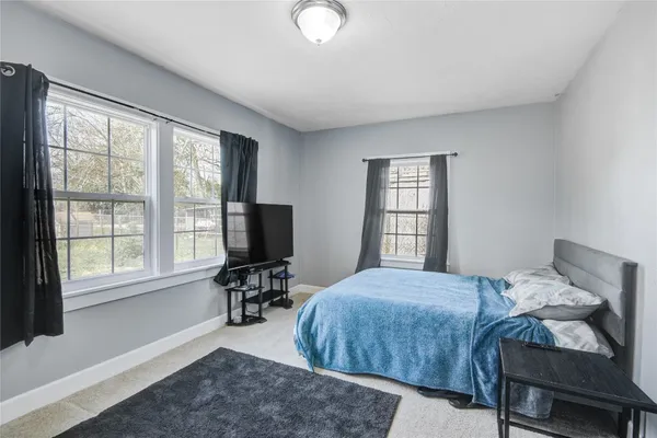 a bedroom with a bed and a flat tv screen on the dresser