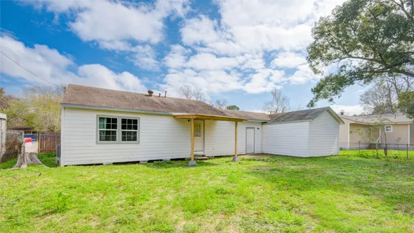 a view of a house with yard and a large tree