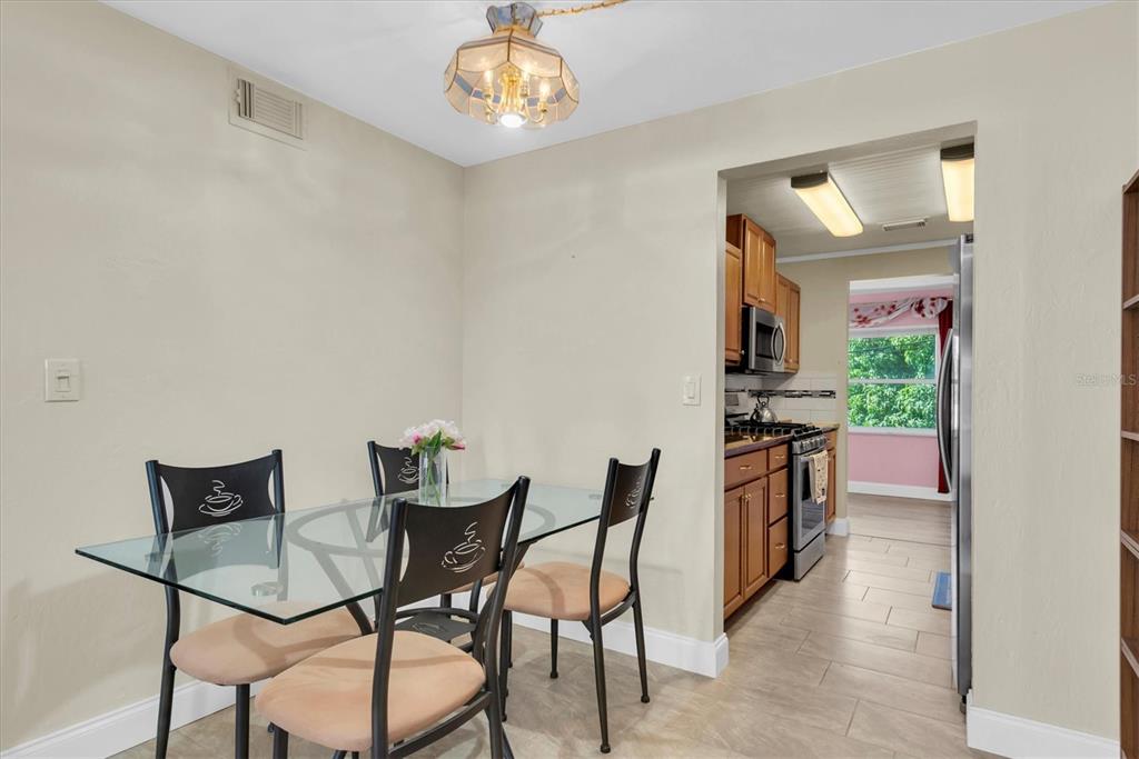 10032 65th Avenue North, Unit 24 St. Petersburg, FL 33708 - Photo 12 of 56 a view of a dining room with furniture and a chandelier