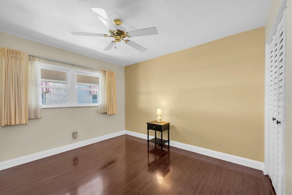 10032 65th Avenue North, Unit 24 St. Petersburg, FL 33708 - Photo 13 of 56 a view of an empty room with wooden floor and a window