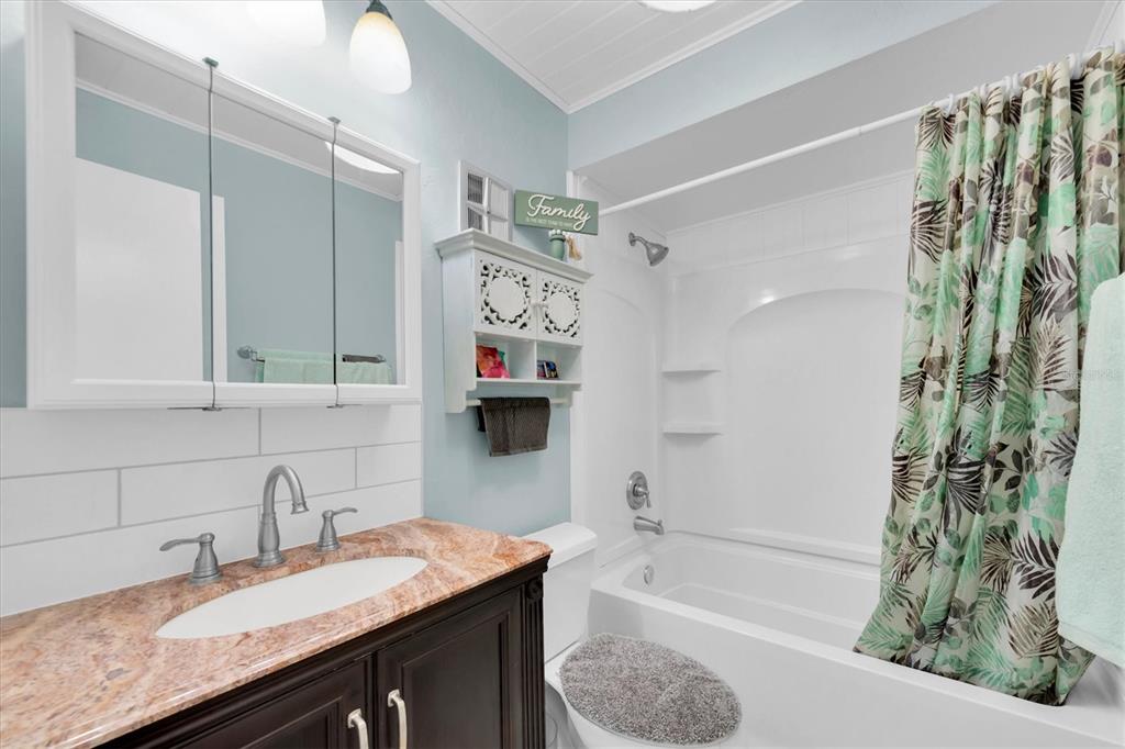 10032 65th Avenue North, Unit 24 St. Petersburg, FL 33708 - Photo 16 of 56 a bathroom with a granite countertop sink a toilet and shower