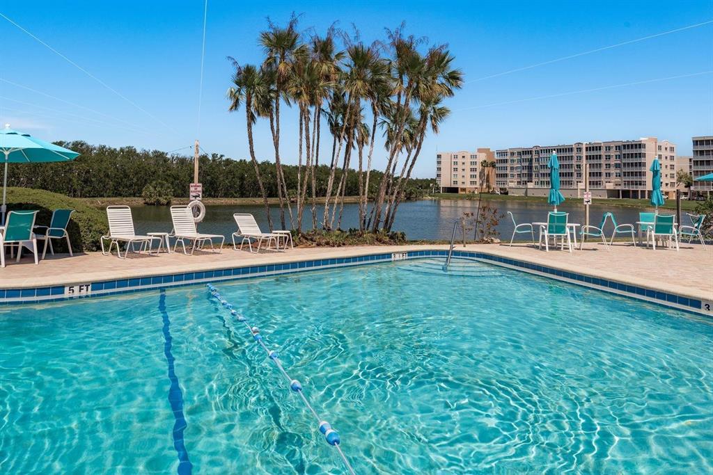 10032 65th Avenue North, Unit 24 St. Petersburg, FL 33708 - Photo 30 of 56 a backyard of a house with table and chairs