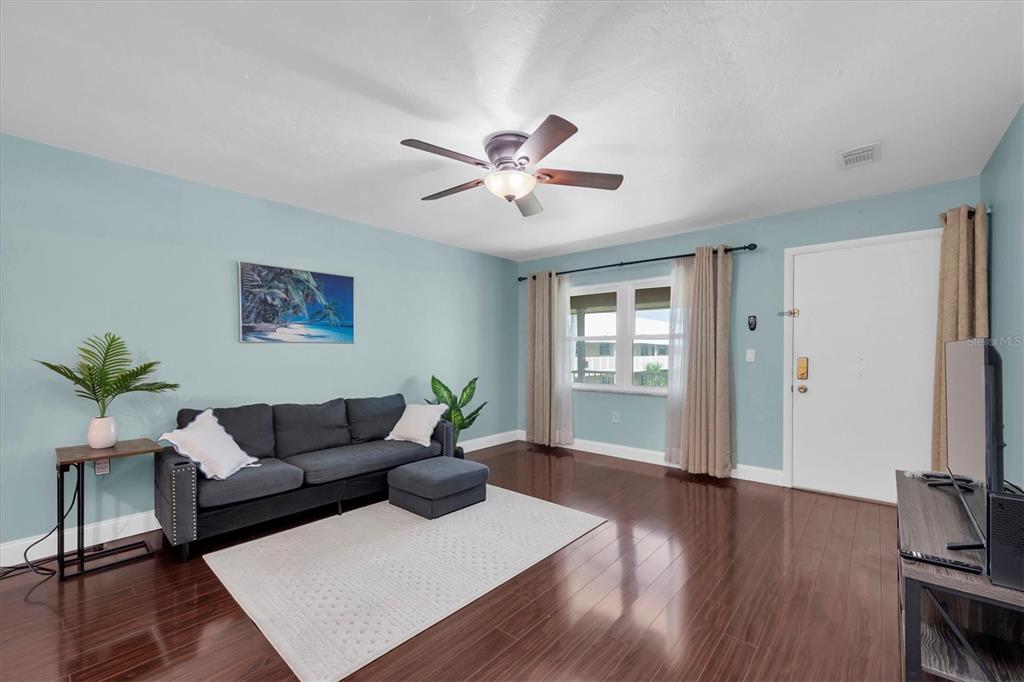 10032 65th Avenue North, Unit 24 St. Petersburg, FL 33708 - Photo 7 of 56 a living room with furniture and wooden floor