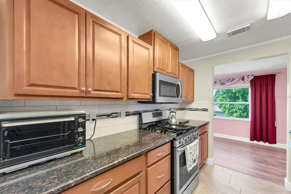 a kitchen with stainless steel appliances granite countertop a sink a stove and a refrigerator