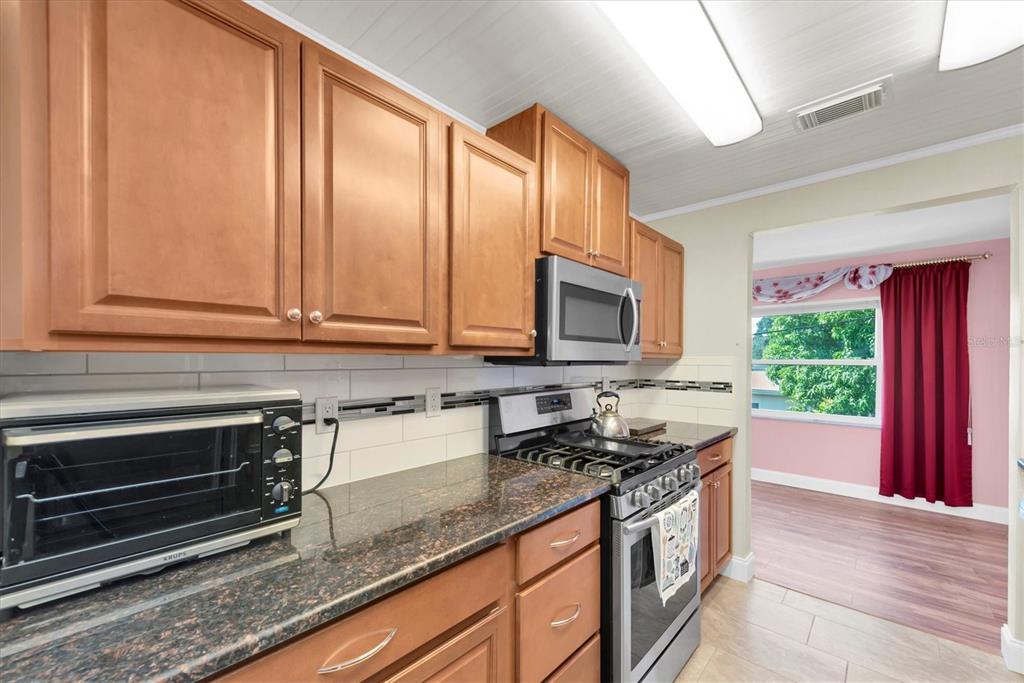 10032 65th Avenue North, Unit 24 St. Petersburg, FL 33708 - Photo 8 of 56 a kitchen with stainless steel appliances granite countertop a stove a sink and a microwave