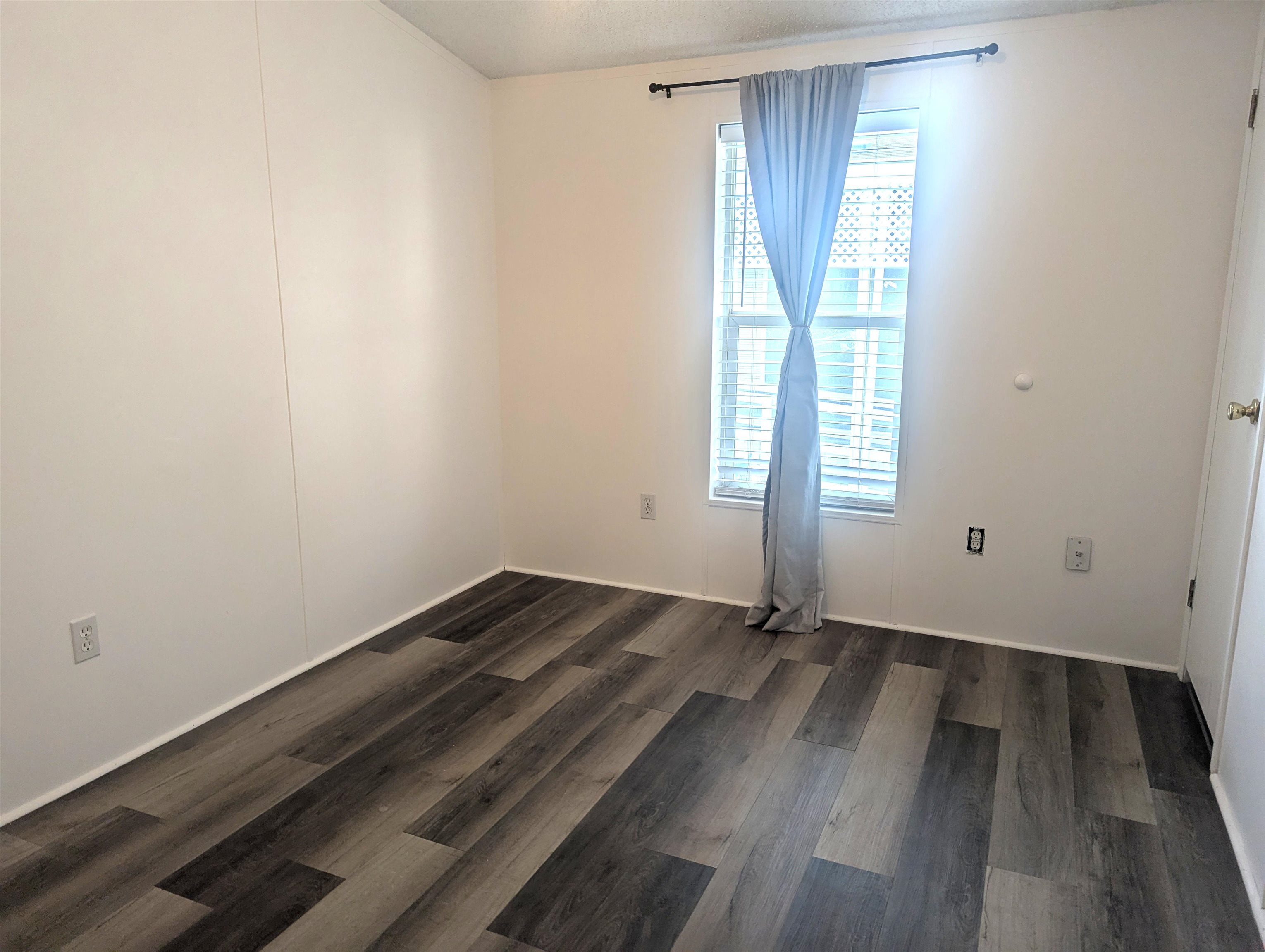 435 32 Road, Unit 254 Clifton, CO 81520 - Photo 20 of 21 an empty room with wooden floor and windows
