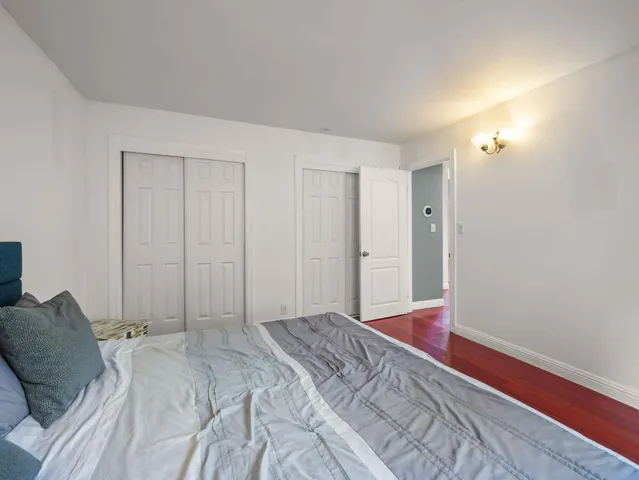 a bedroom with a bed and a wooden floor