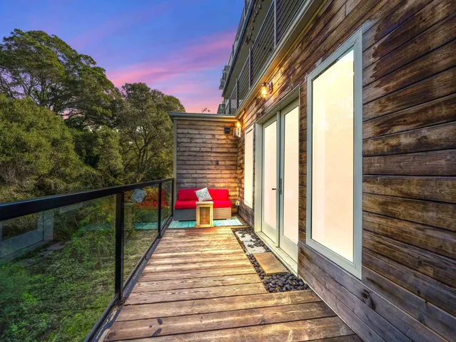 a view of a balcony with wooden floor and a potted plant