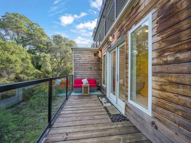 a view of a balcony with wooden floor and a potted plant