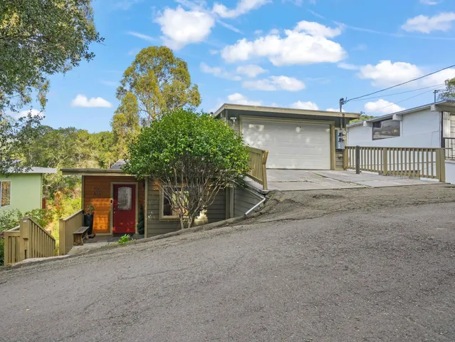a view of a house with large space and a car parked in front of it