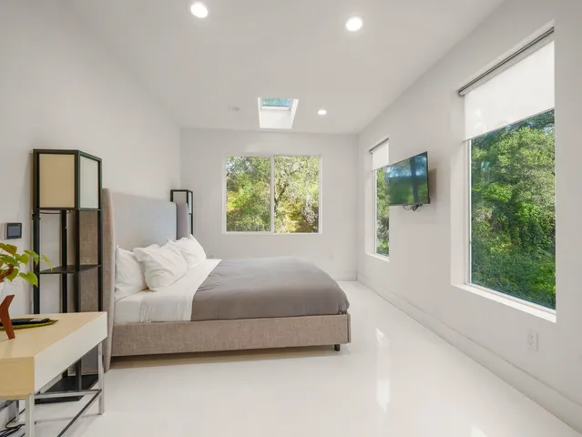 a bedroom with a large bed and windows