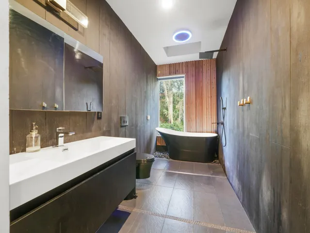 a bathroom with a tub sink and mirror