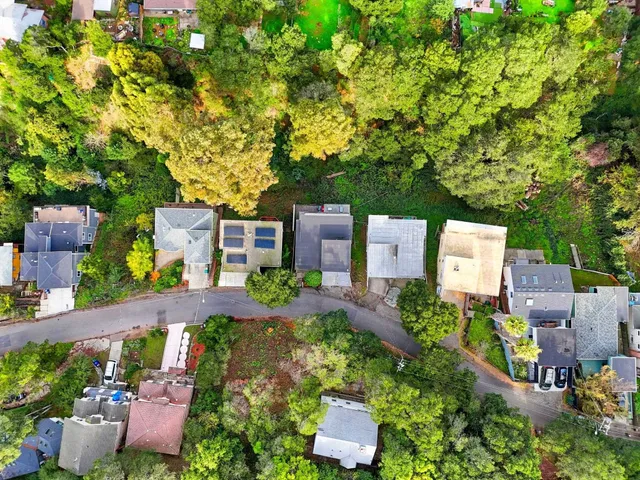 an aerial view of a house with garden space and street view