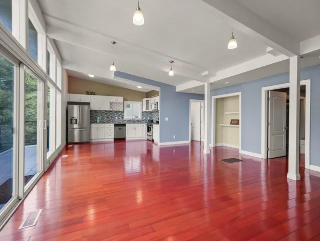 a view of empty room with wooden floor and windows
