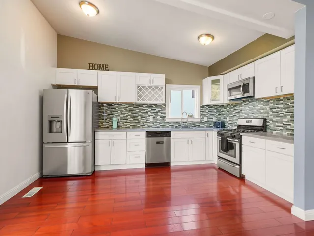 a kitchen with granite countertop white cabinets and stainless steel appliances