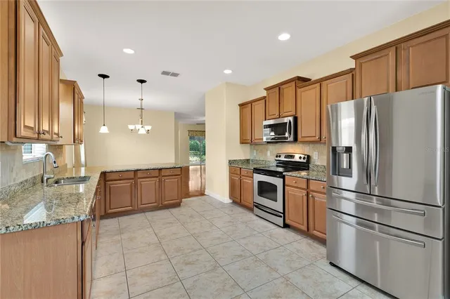 a kitchen with stainless steel appliances granite countertop a refrigerator sink and stove