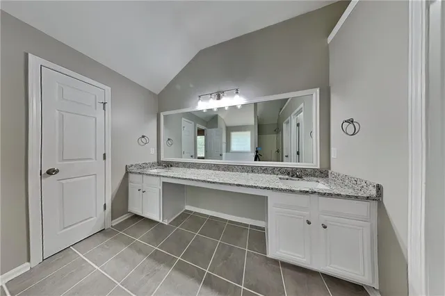 a bathroom with a granite countertop sink a mirror and a vanity