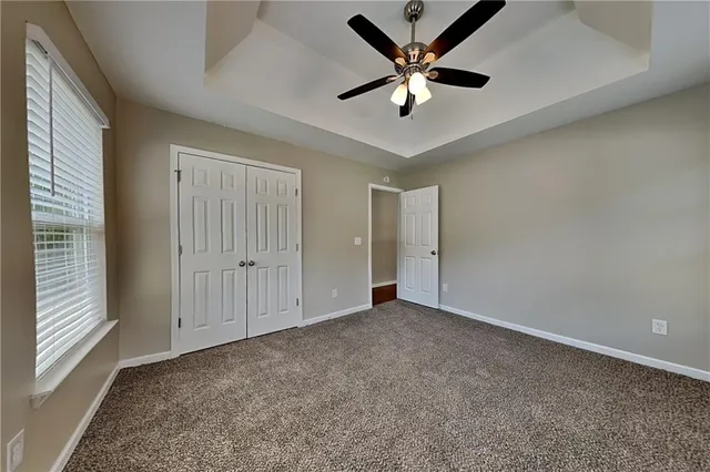 an empty room with fan and windows