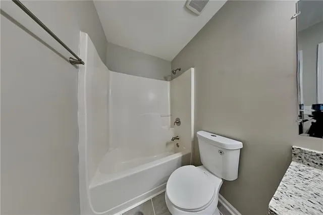 a white toilet sitting next to a bath tub