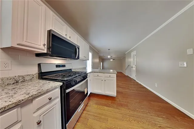 a kitchen with granite countertop wooden cabinets and a stove top oven