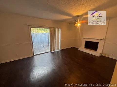 a view of a livingroom with wooden floor and a fireplace