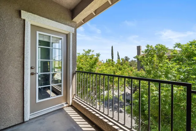 a view of a balcony with a floor to ceiling window and wooden fence