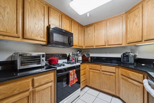 a kitchen with stainless steel appliances granite countertop a stove sink microwave and cabinets