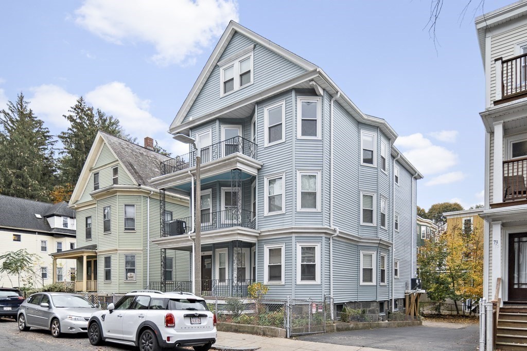 75 Tower Street, Unit 1 Boston, MA 02130 - Photo 15 of 16 a view of a white building among the street with palm trees