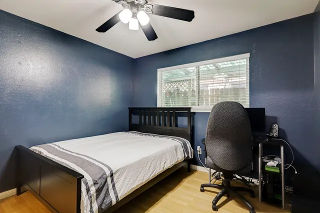 a bedroom with a bed chair and a desk