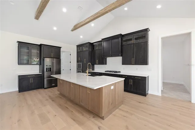 a kitchen with stainless steel appliances granite countertop a lot of counter space and wooden floors