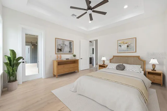 a bedroom with a large bed and a chandelier