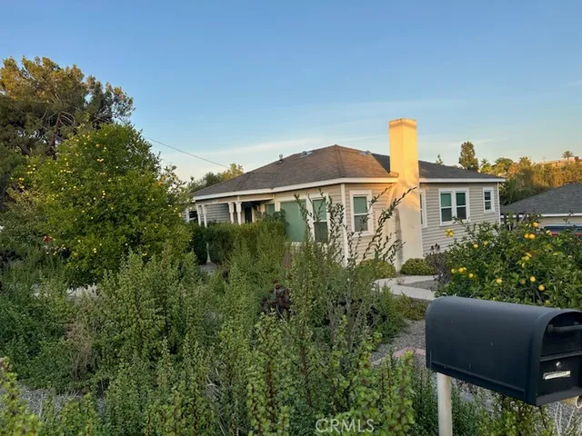 a view of a house with garden and sitting area