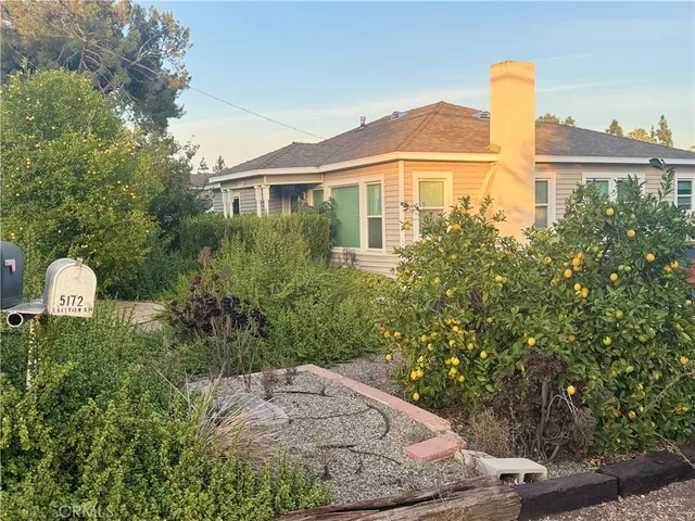 a front view of a house with a yard and trees