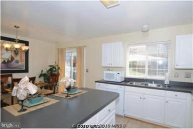 7417 Maury Road Windsor Mill, MD 21244 - Photo 3 of 19 a kitchen with kitchen island granite countertop a sink and white cabinets