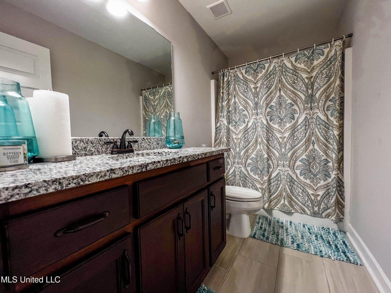 2364 Nikki Ridge Drive Nesbit, MS 38651 - Photo 22 of 26 a bathroom with a granite countertop sink toilet and a mirror