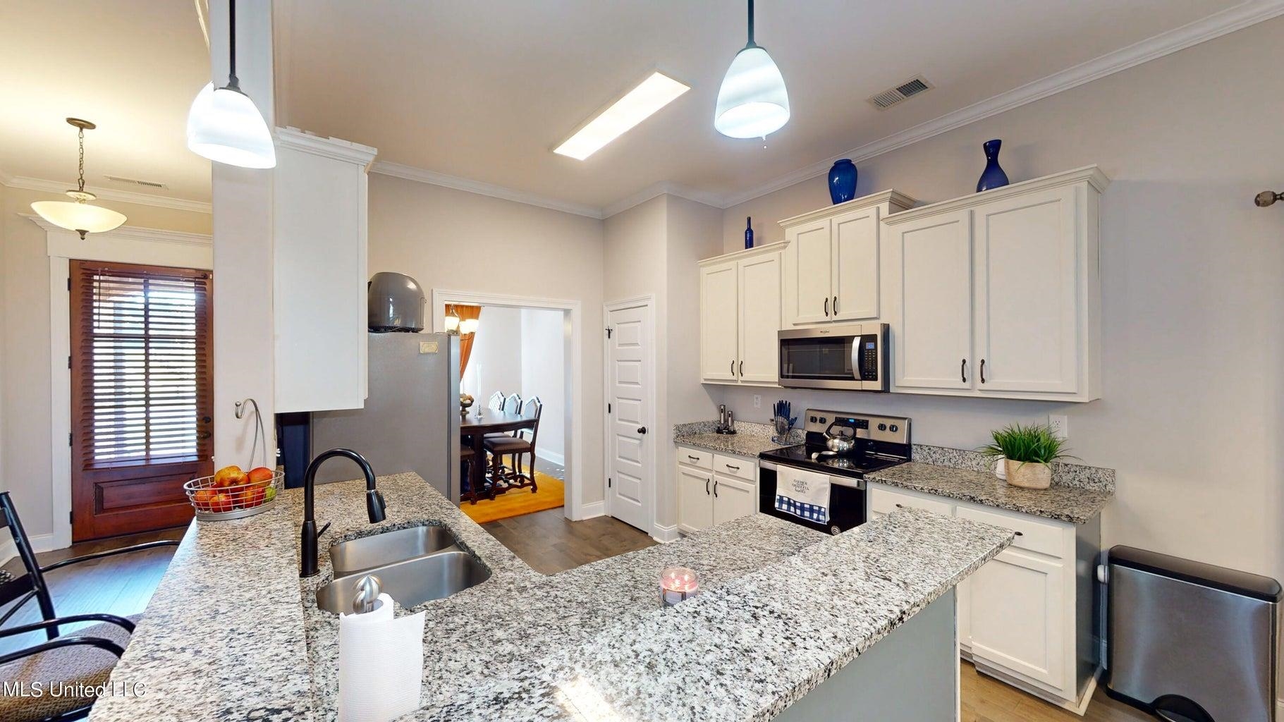 2364 Nikki Ridge Drive Nesbit, MS 38651 - Photo 6 of 26 a kitchen with stainless steel appliances granite countertop a stove top oven a sink a counter space and cabinets