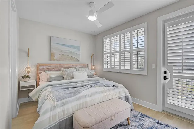 a living room with furniture floor to ceiling window and a ceiling fan