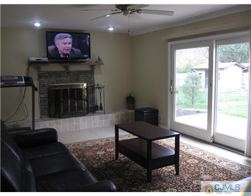6 Purdue Road Edison, NJ 08820 - Photo 10 of 15 a living room with furniture a flat screen tv and a fireplace