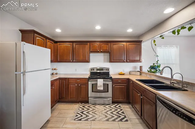 a kitchen with stainless steel appliances granite countertop a sink stove and refrigerator