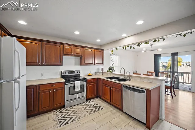 a kitchen with stainless steel appliances granite countertop a sink stove and refrigerator