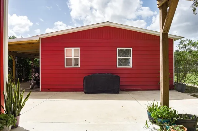 a view of a back yard with table and chairs under an umbrella