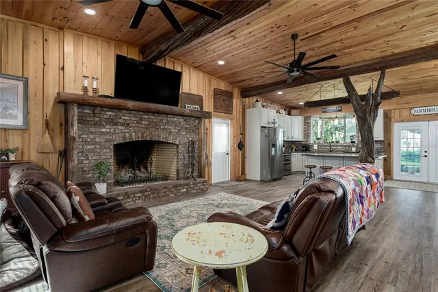 a kitchen with stainless steel appliances granite countertop a refrigerator a sink dishwasher a stove and white countertops with wooden floor