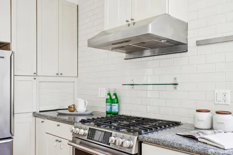 a stove top oven sitting inside of a kitchen
