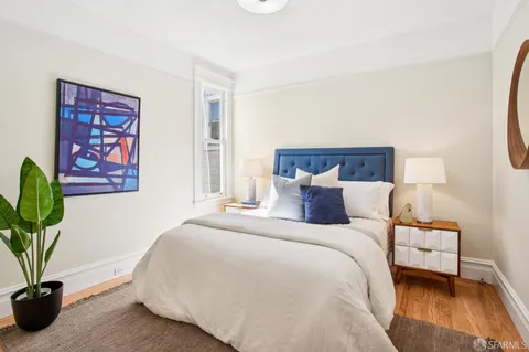 a bedroom with a bed and a potted plant