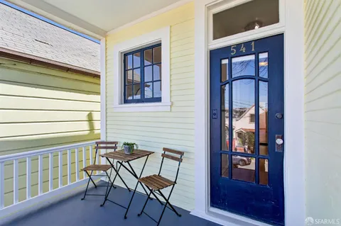 a view of a brick house with a chairs and table in a balcony