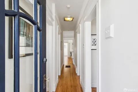 a view of a hallway with wooden floor