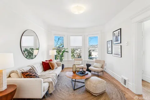 a living room with furniture a rug and a window