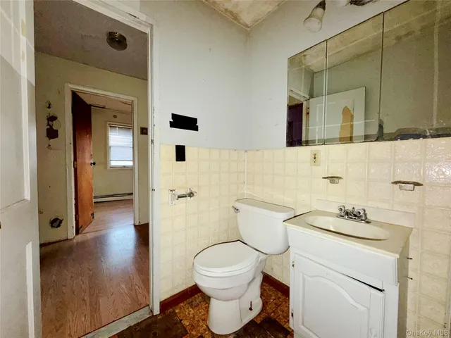 a bathroom with a granite countertop toilet sink and mirror